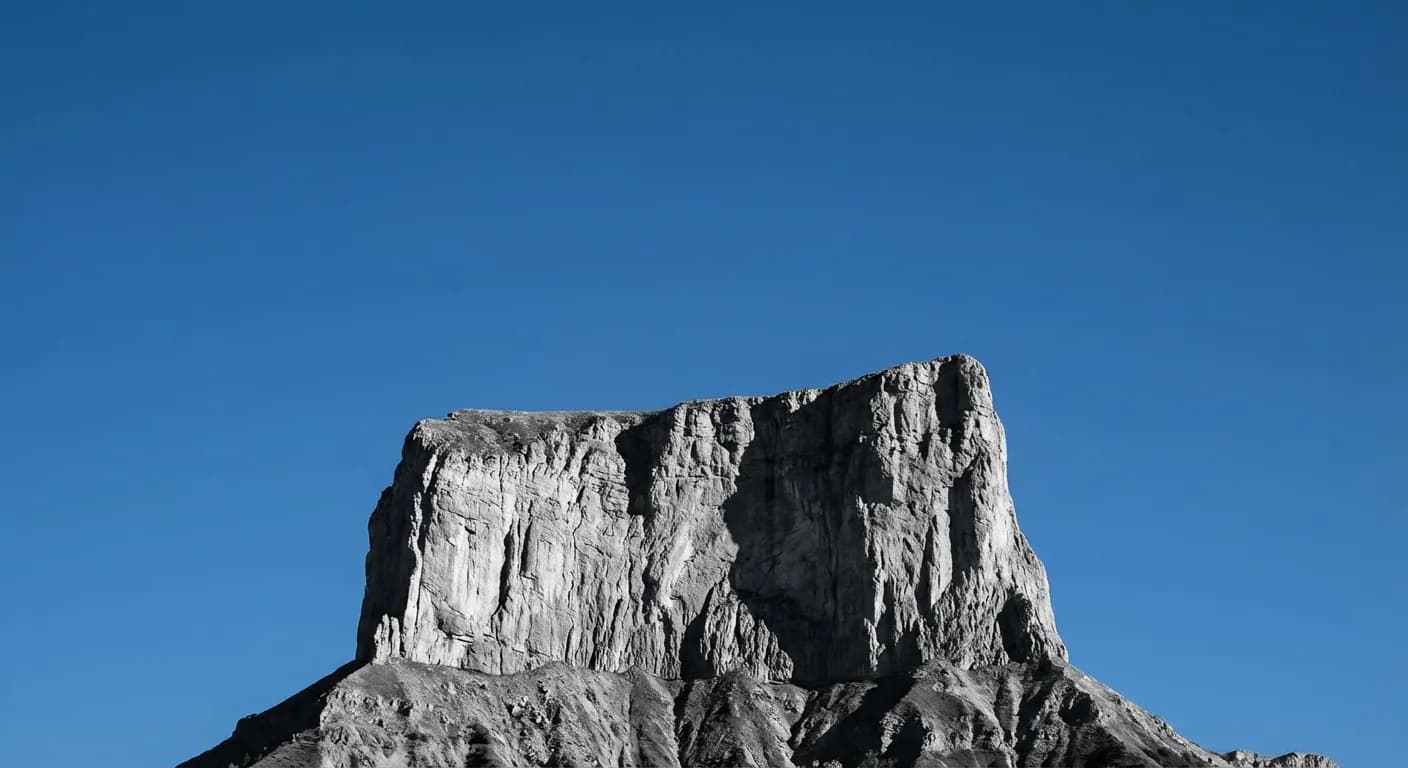 Silhouette minimaliste du Mont Aiguille sur fond de ciel bleu