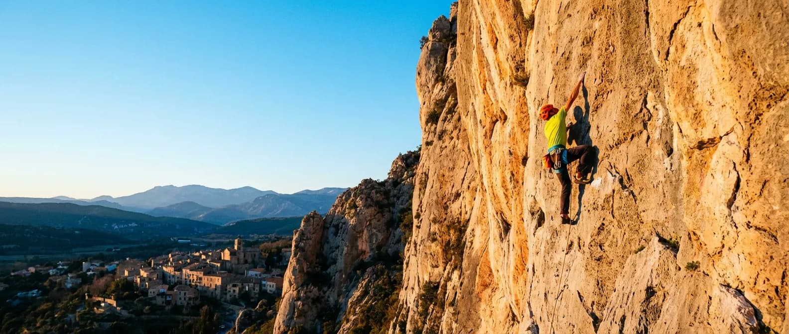 Escalade majestueuse sur les falaises de Tautavel Vue panoramique épique d'un grimpeur sur les falaises de calcaire de Tautavel au soleil couchant.