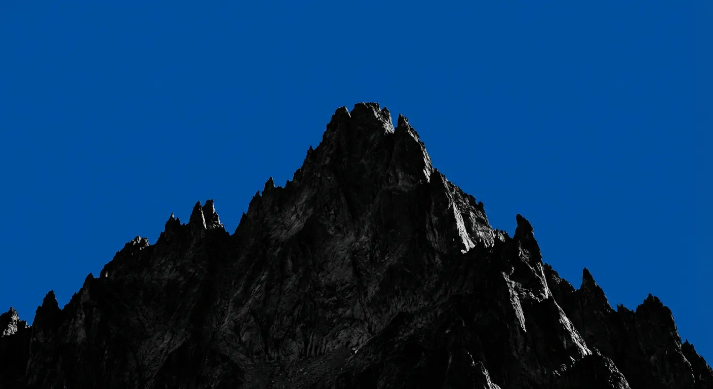 Silhouette emblématique de la Pointe Trifide sous un ciel bleu alpin